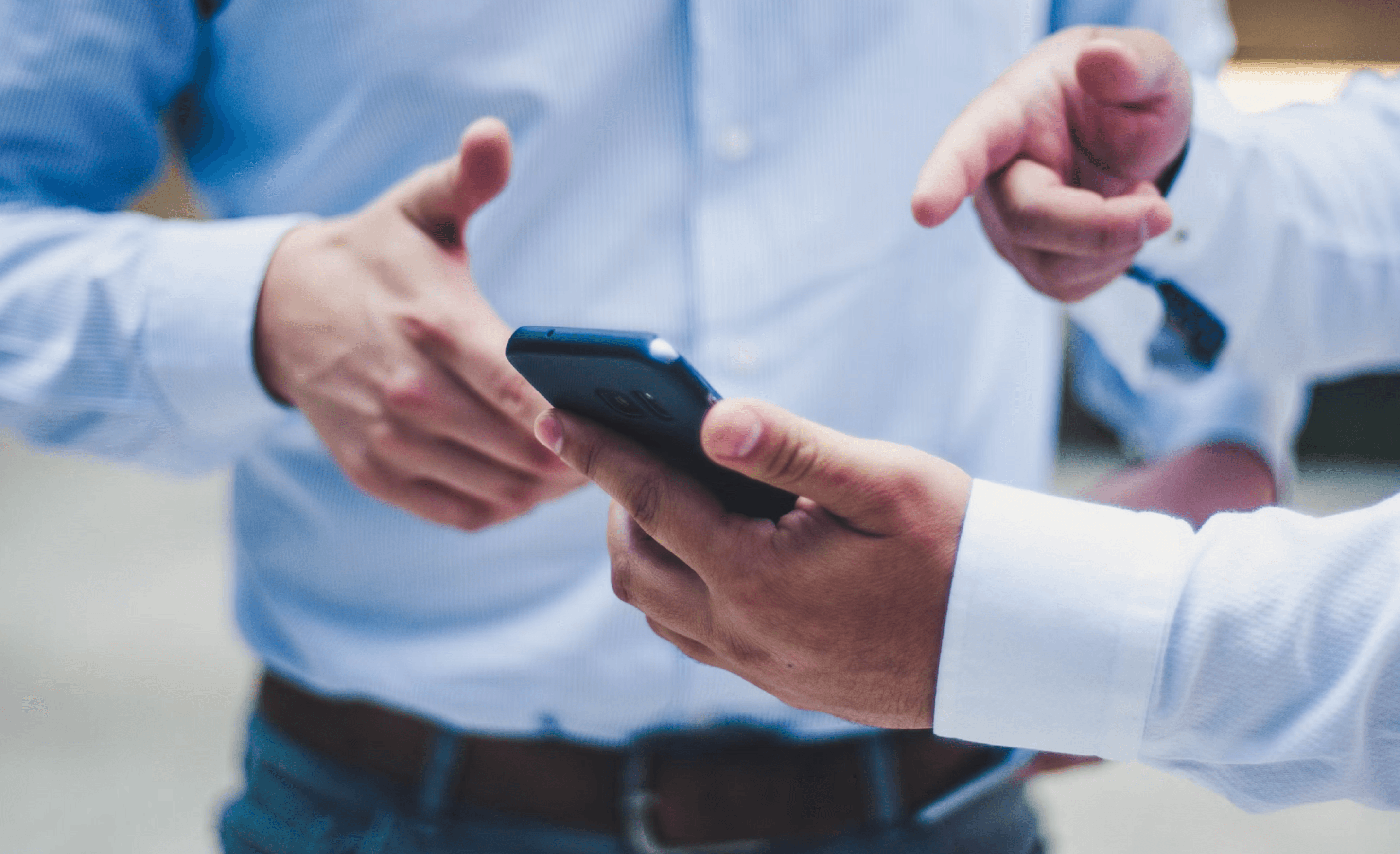 Two people looking and pointing at a phone